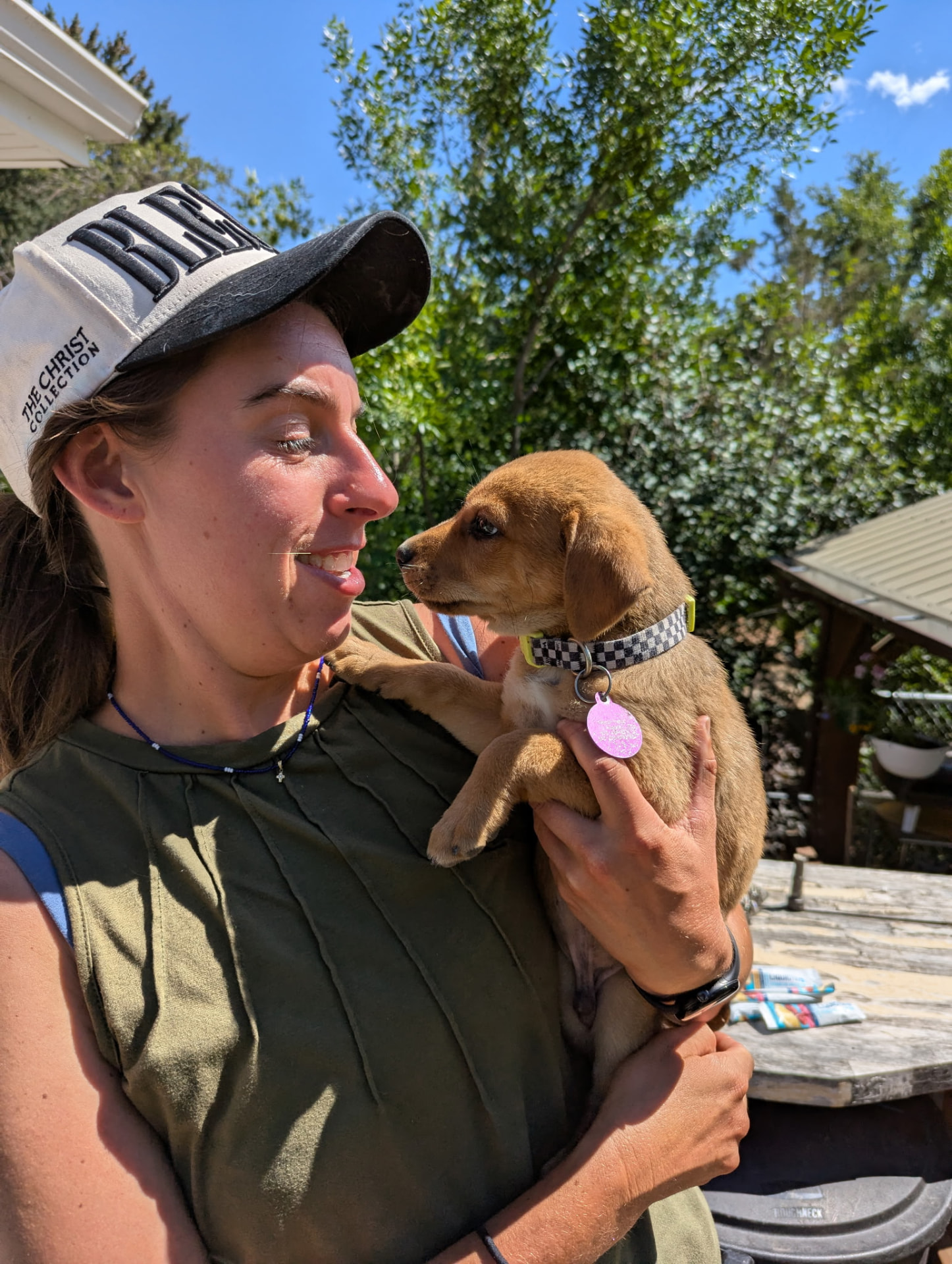 Sarah holding a young puppy outside on a sunny Northern Colorado afternoon